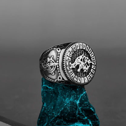 Silver ring with intricate designs on a dark gray background