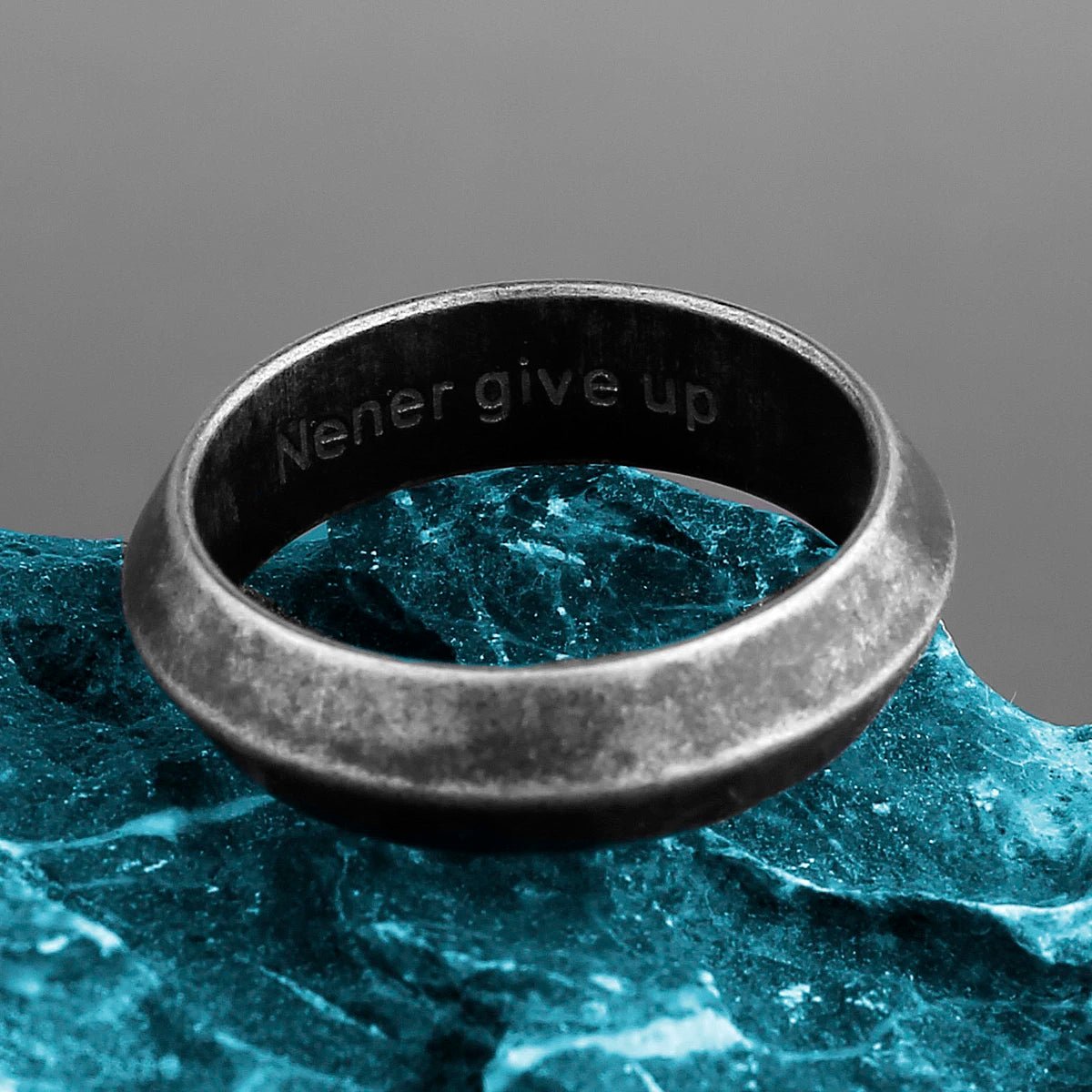 Stainless steel Viking ring engraved with "Never give up" on the inside band.