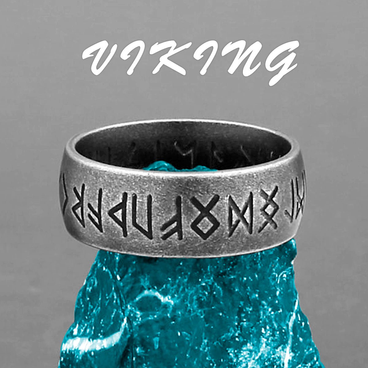 Viking rune ring in stainless steel with Norse symbols encircling the band, displayed on a blue crystal.