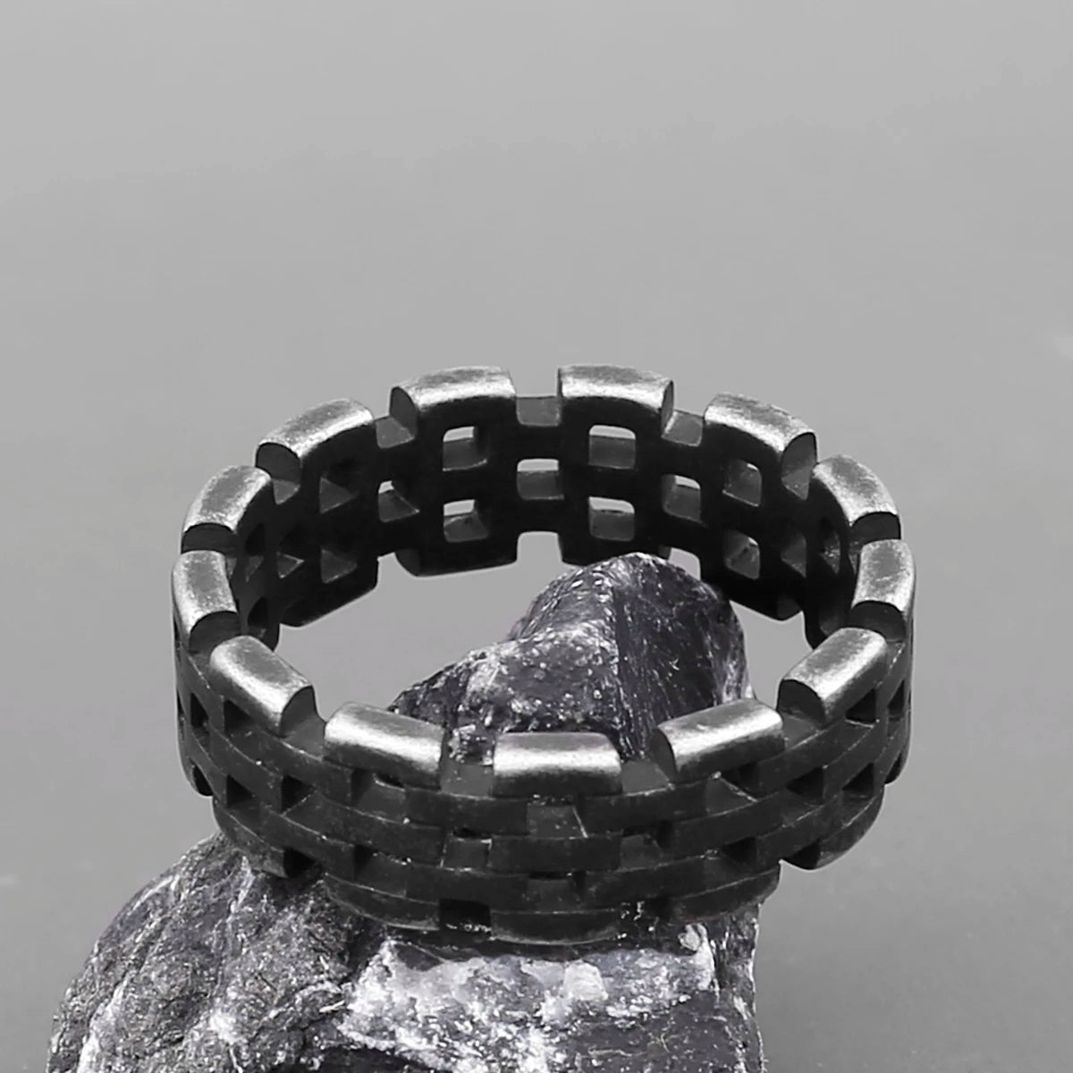 Silver stainless steel woven Viking ring displayed on a rock.