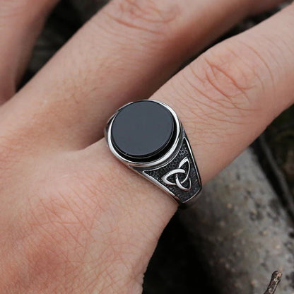 The Trinity of Power Ring worn on hand, showing polished black stone and Norse Trinity Knot engravings.