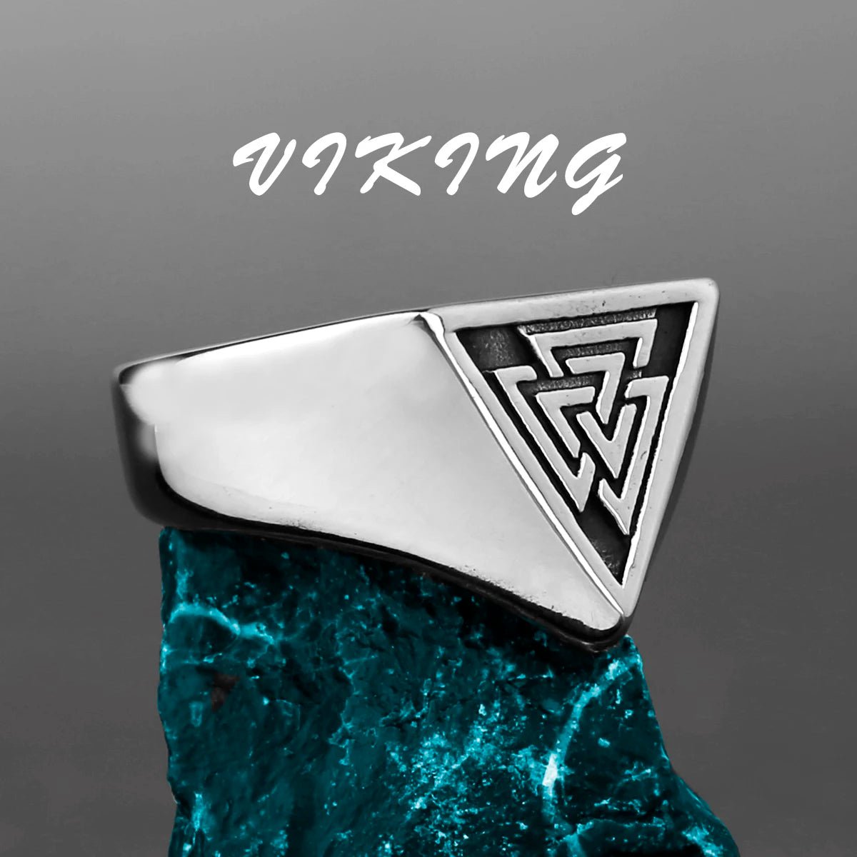 Sleek stainless steel Viking ring featuring the Valknut symbol in a triangular design, displayed on a textured blue stone.