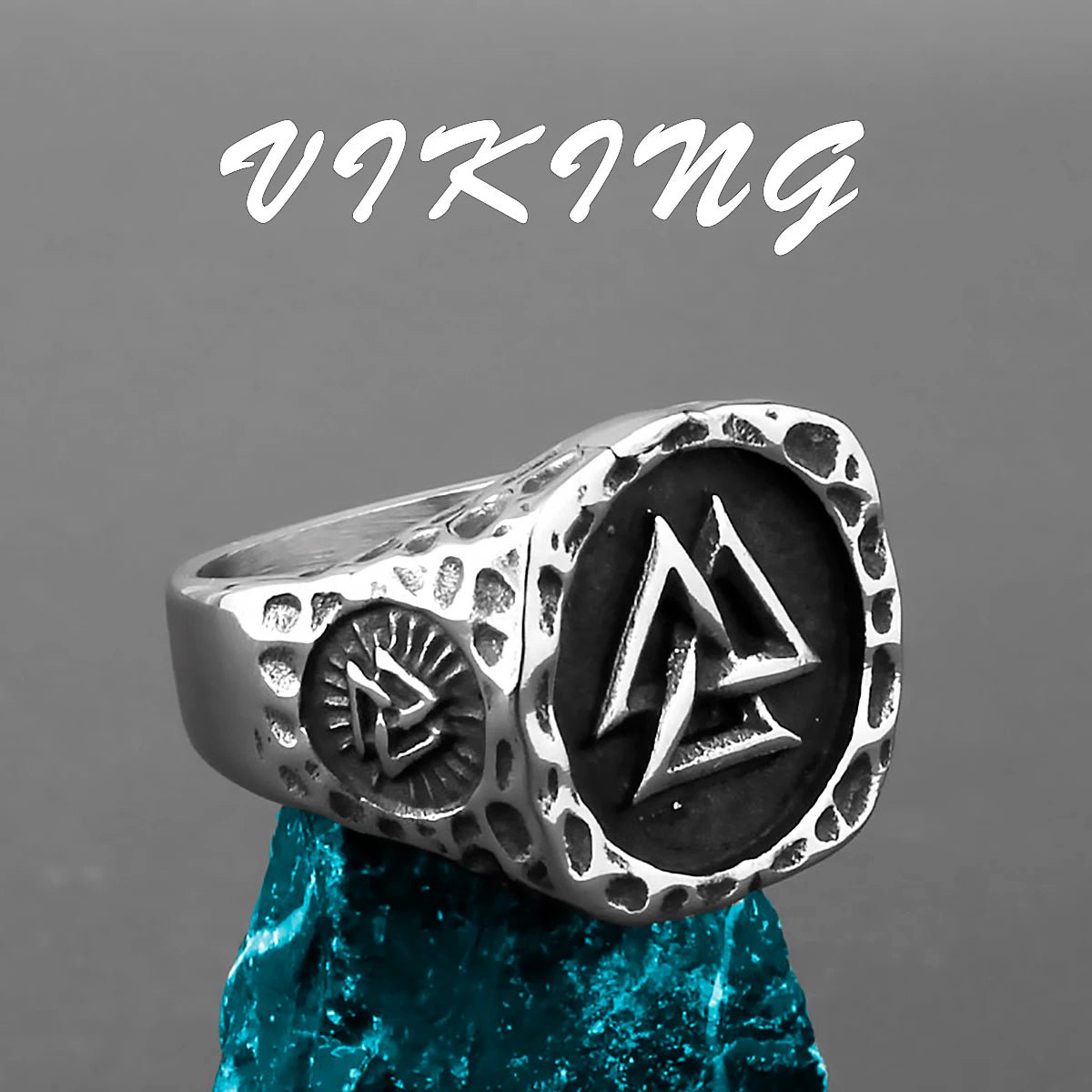 Hammered stainless steel Viking ring featuring a raised Valknut symbol and intricate Norse detailing, set on a textured blue stone.